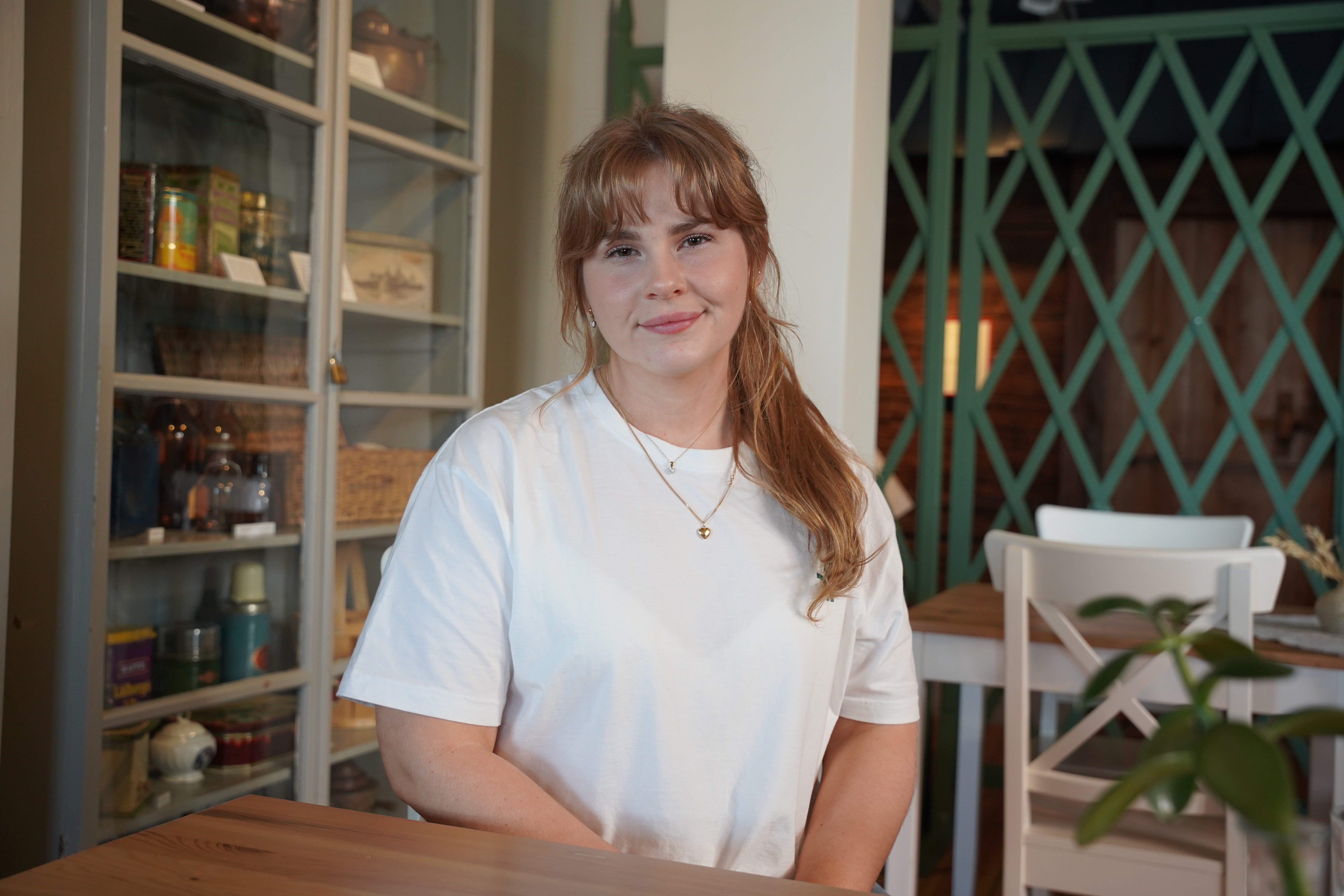 Livia sitter i ett ombonat kök med ett varmt och lugnt leende